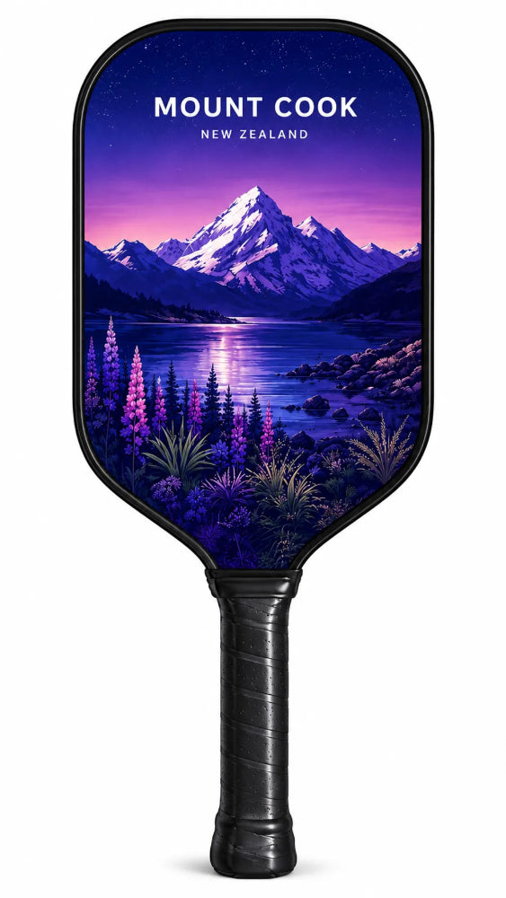 A pickleball paddle featuring a scenic Mount Cook landscape print from New Zealand, with a black handle and black trim, shown against a plain white background.