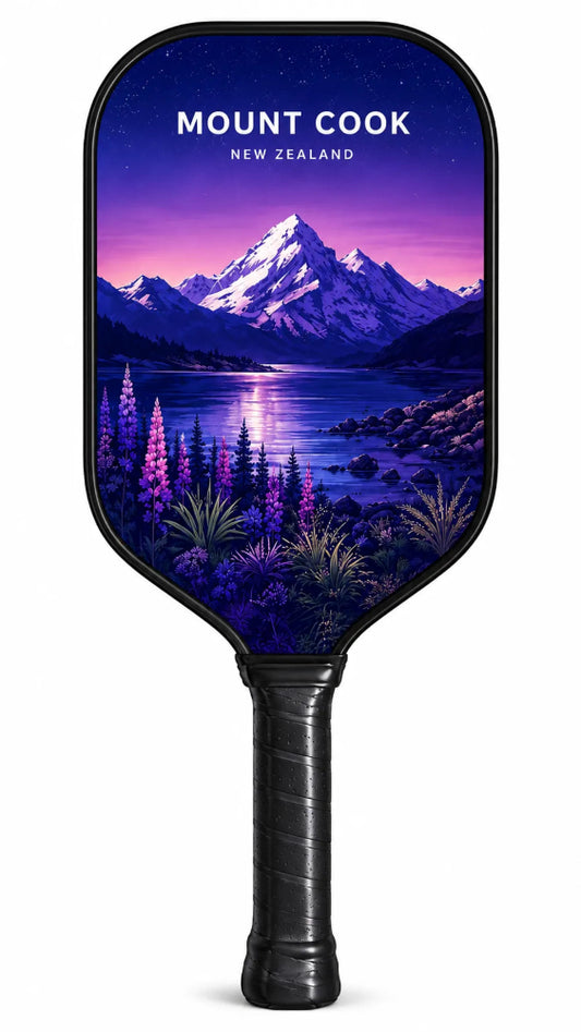 A pickleball paddle featuring a scenic Mount Cook landscape print from New Zealand, with a black handle and black trim, shown against a plain white background.