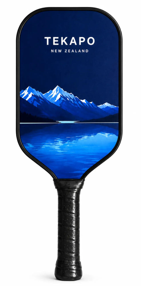 A pickleball paddle featuring a blue graphic of Mount Taranaki in New Zealand with the text 'TEKAPO NEW ZEALAND' on the paddle face, and a black wrapped handle, shown against a white background.